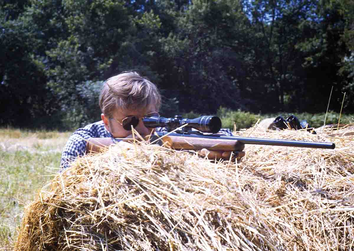 Using his favorite Ruger No. 1 rifle in 22-250 Remington some years back, illustrates how shooters can use various farm props like this hay bale to steady-up any long-range shot.